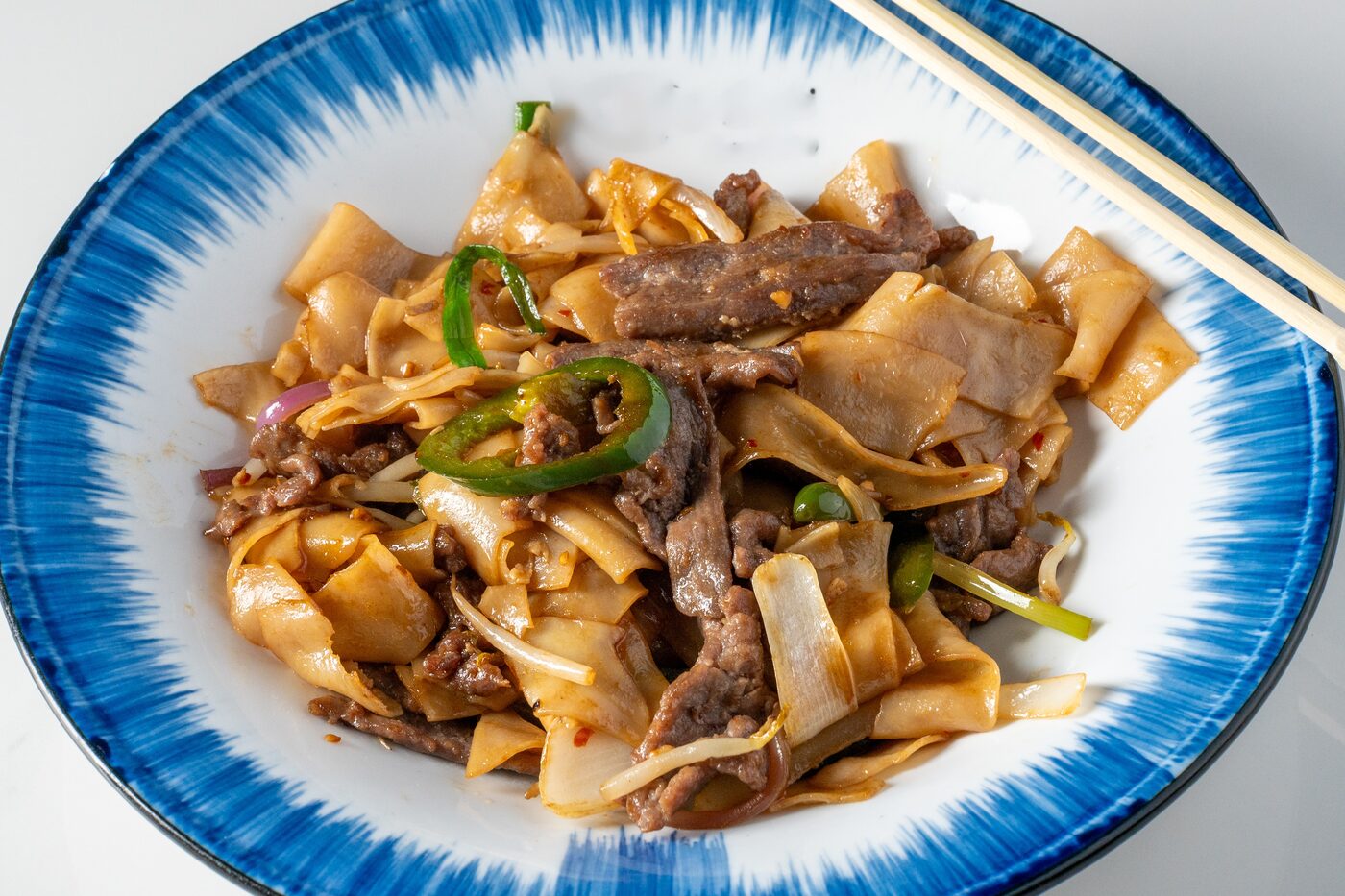 Drunken Noodles with beef, wide rice noodles and Thai basil - East Moon Centennial
