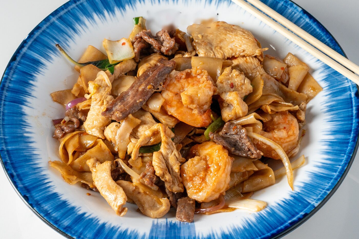 Drunken Noodles combination with chicken, beef and shrimp - East Moon Centennial CO