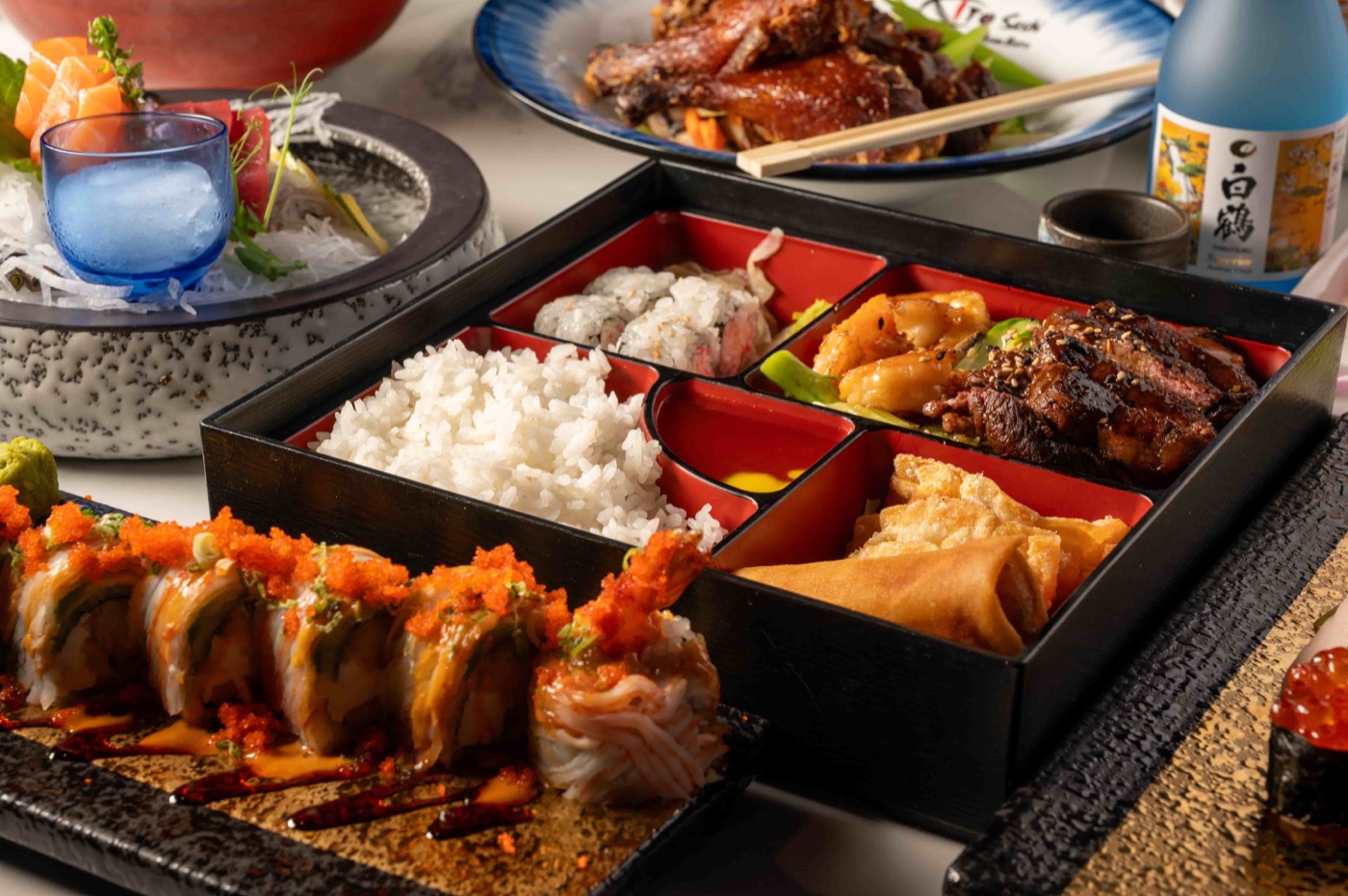 Lunch spread with bento box, sashimi plate and a specialty sushi roll - East Moon Asian Bistro Centennial CO