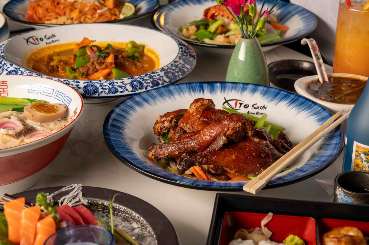 Dinner table set with roast duck, Thai curry, ramen, sashimi and Pad Thai - East Moon Asian Bistro Centennial CO