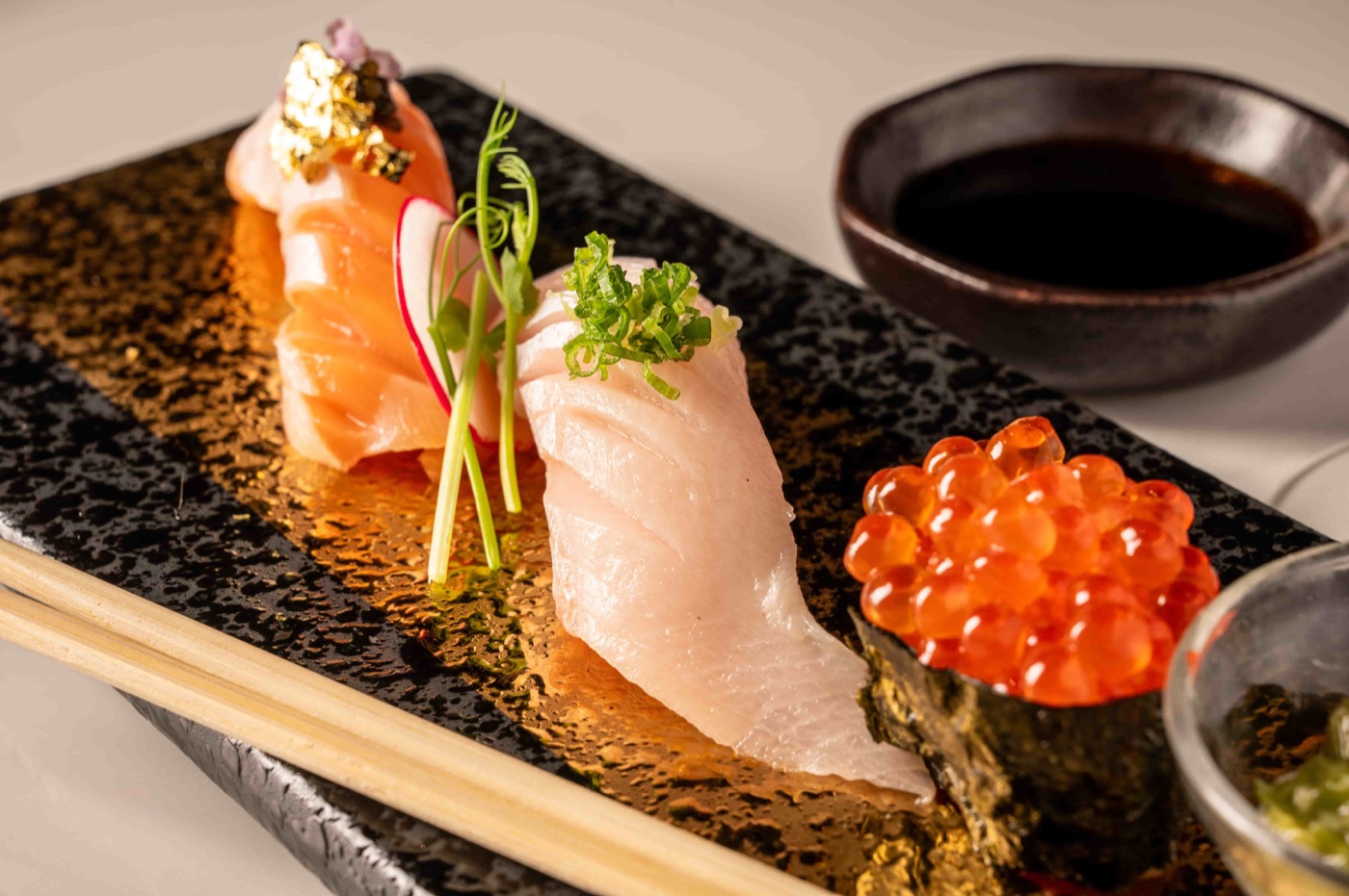 Assorted nigiri sushi with salmon, white fish and salmon roe on a slate plate - East Moon Centennial CO
