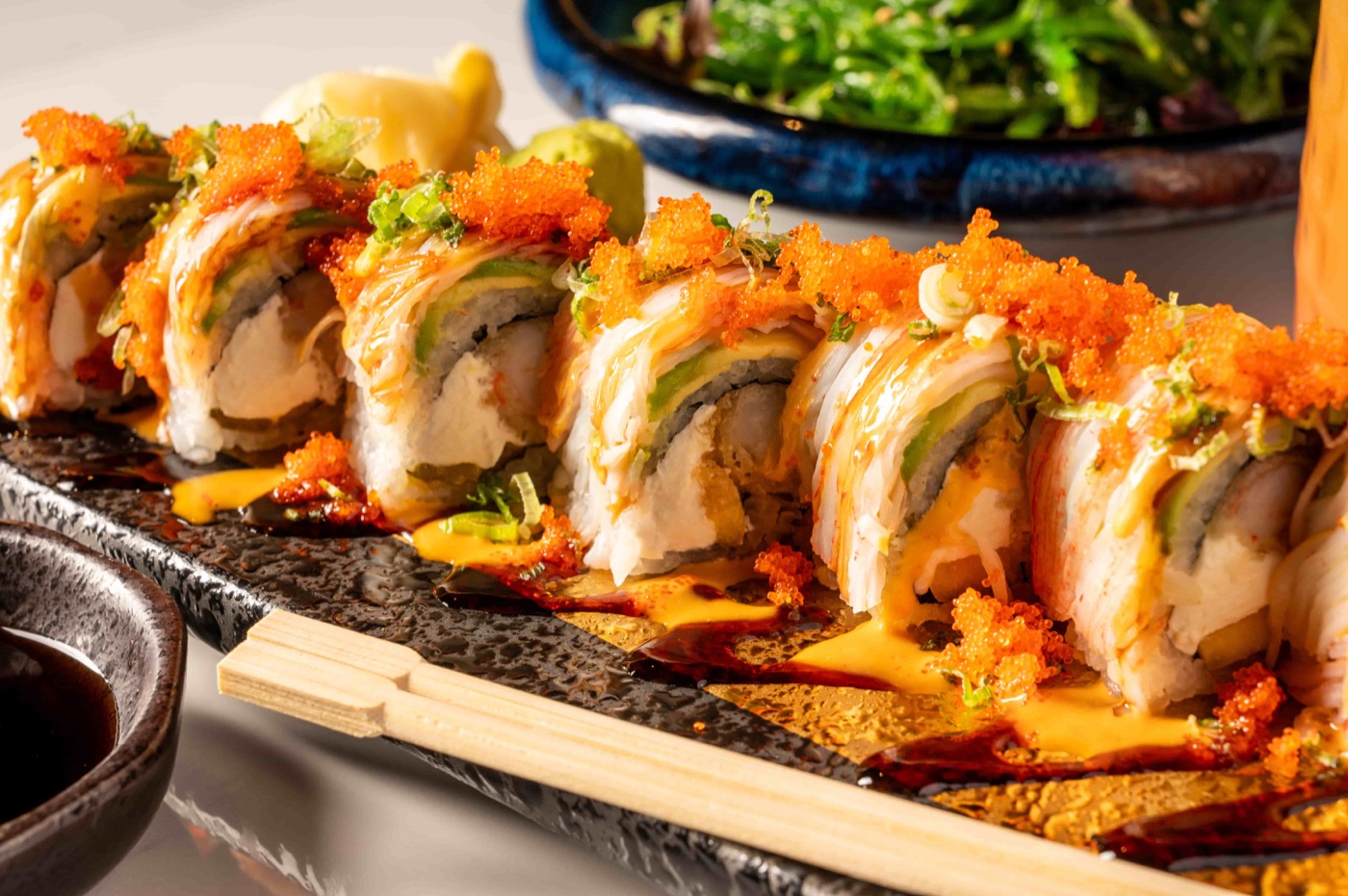 Phoenix Roll sushi with shrimp tempura, cream cheese and mango topped with avocado and crabmeat - East Moon Asian Bistro Centennial CO
