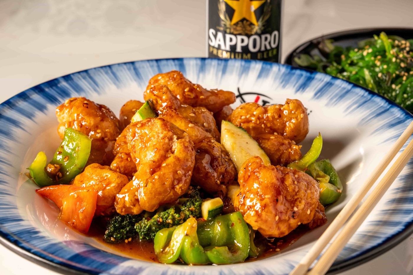 Sesame Chicken glazed in sweet sesame sauce with broccoli, bell pepper and zucchini - East Moon Centennial CO